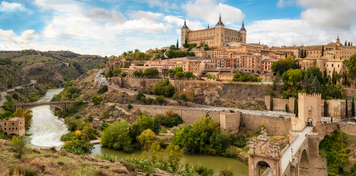 View of Toledo and Puente de Alcantara over Targus River, where you can travel with travel insurance for Spain