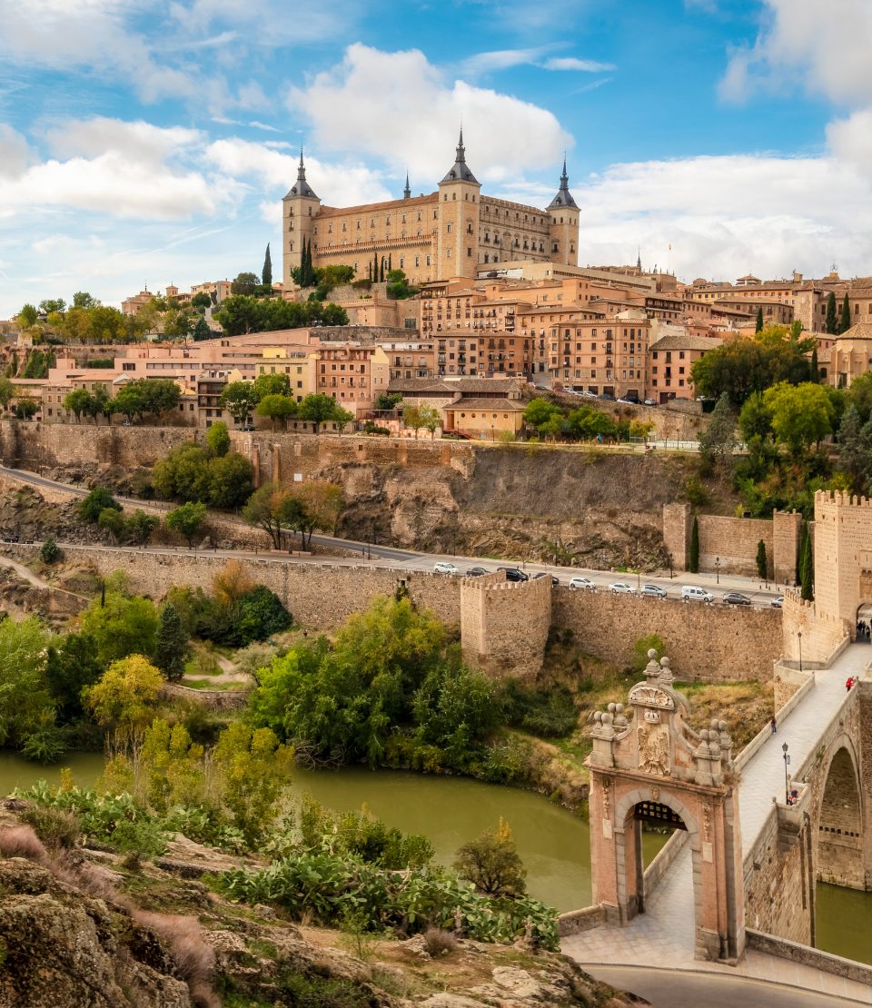 View of Toledo and Puente de Alcantara over Targus River, where you can travel with travel insurance for Spain