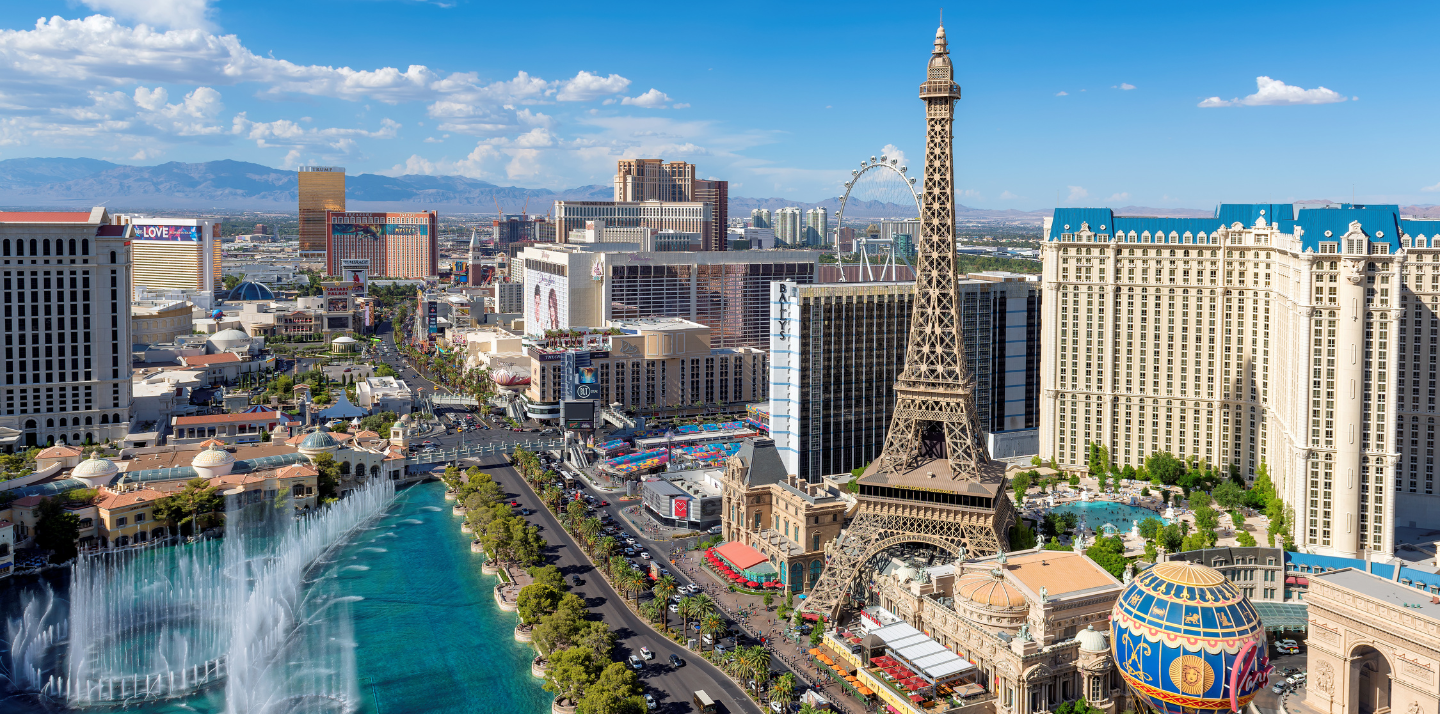 Aerial view of the Eiffel Tower, mountains, and Las Vegas strip highlighting travel insurance for Las Vegas trips