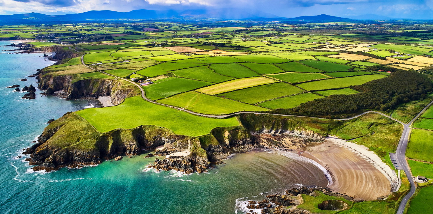 Aerial view of green fields and beach at Copper Coast for travel insurance for Ireland page