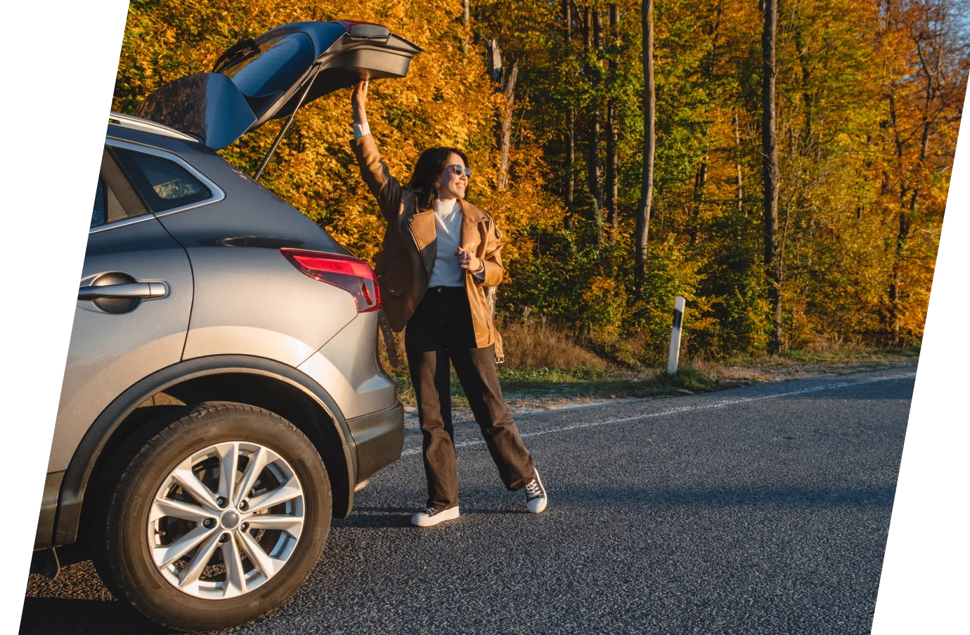 a woman with cancel for any reason travel insurance opens the trunk of her SUV before embarking on an autumn road trip
