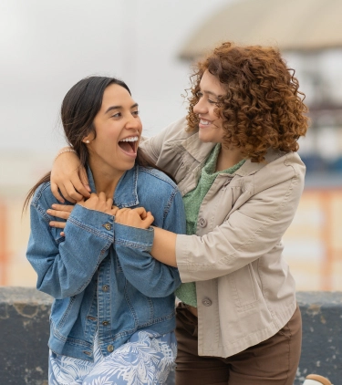 a couple with LGBTQ+ travel insurance embraces outdoors in a casual setting