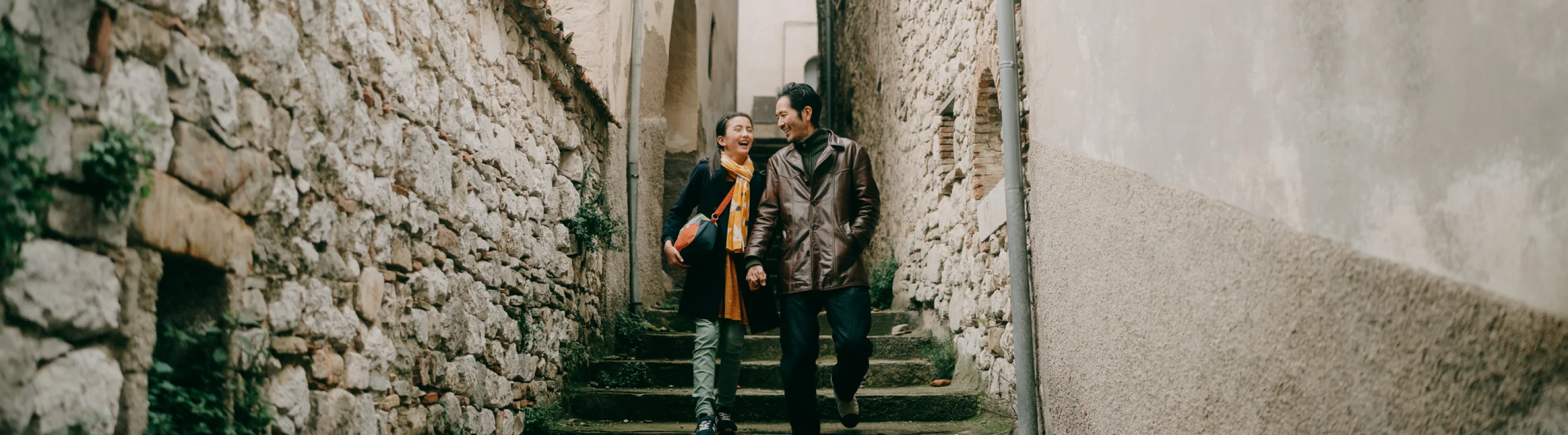 Father and teen daughter walking side by side on an alley in Villa Santa Maria with travel insurance for Italy