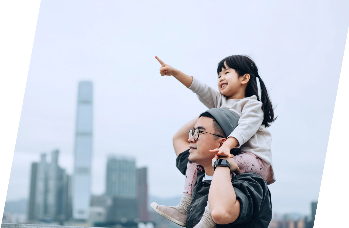 Father with flight insurance carrying his young daughter on his shoulders with the city in the background
