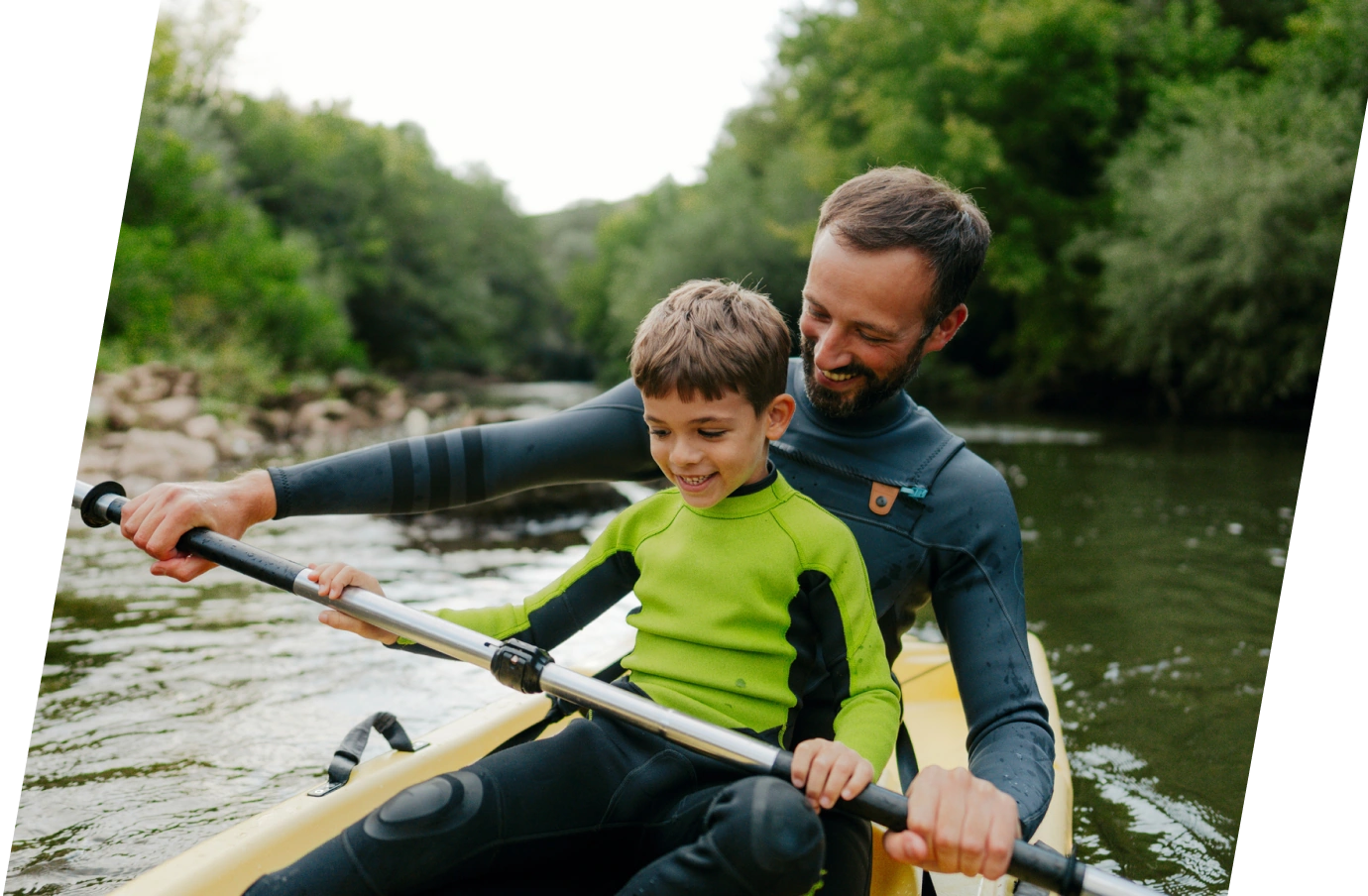 a father and son kayaking in a river on vacation, protected by a family travel insurance plan