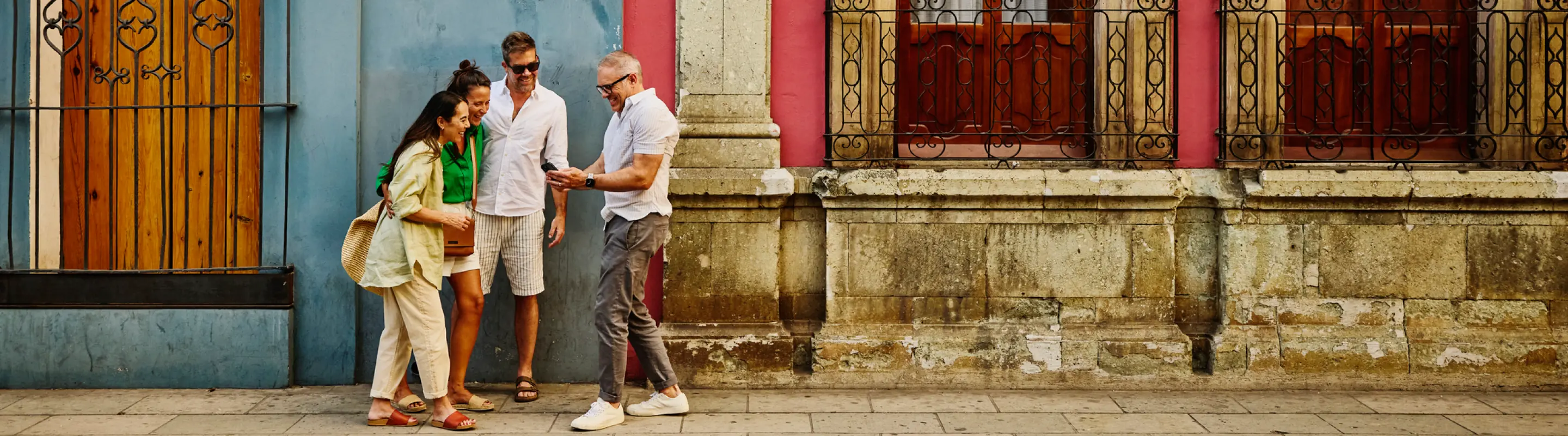 a group of friends with travel insurance for COVID-19, looking at their maps on vacation nearby historic buildings