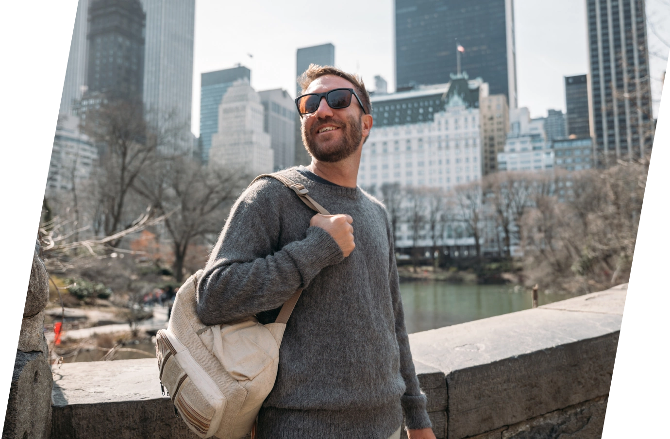 Man with travel insurance for New York holding a backpack in front of the city skyline