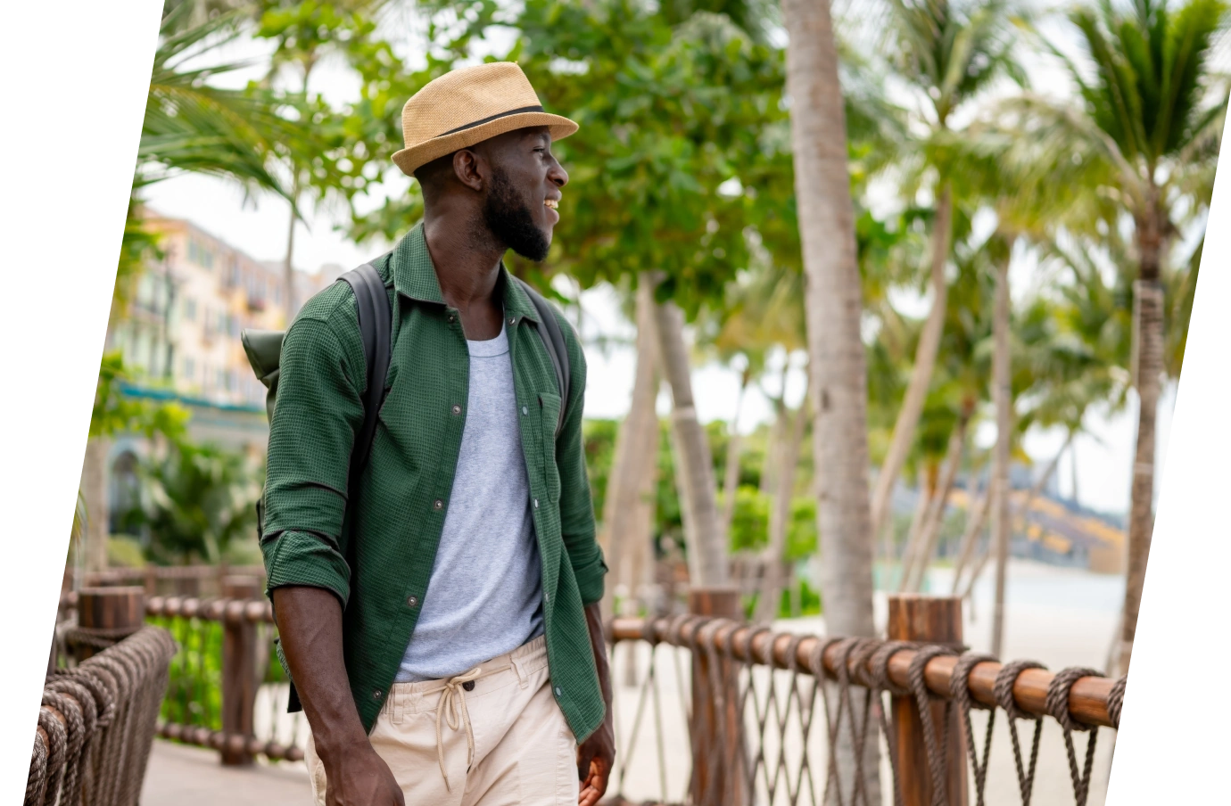 Young man in the Travelex affiliate program looking at the beach while walking on a bridge