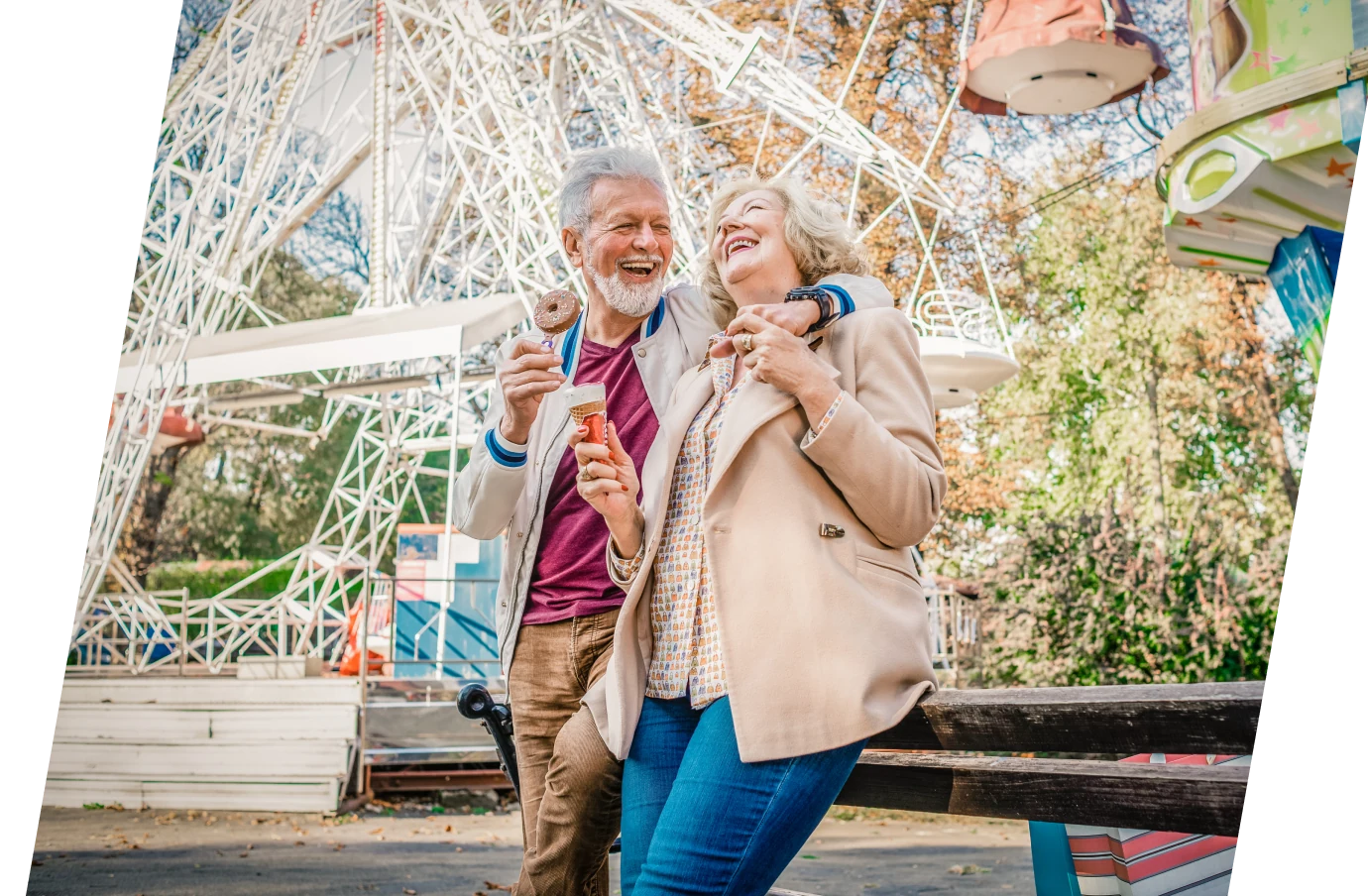 Senior couple with Travelex support on vacation laughing and eating ice cream at a fair