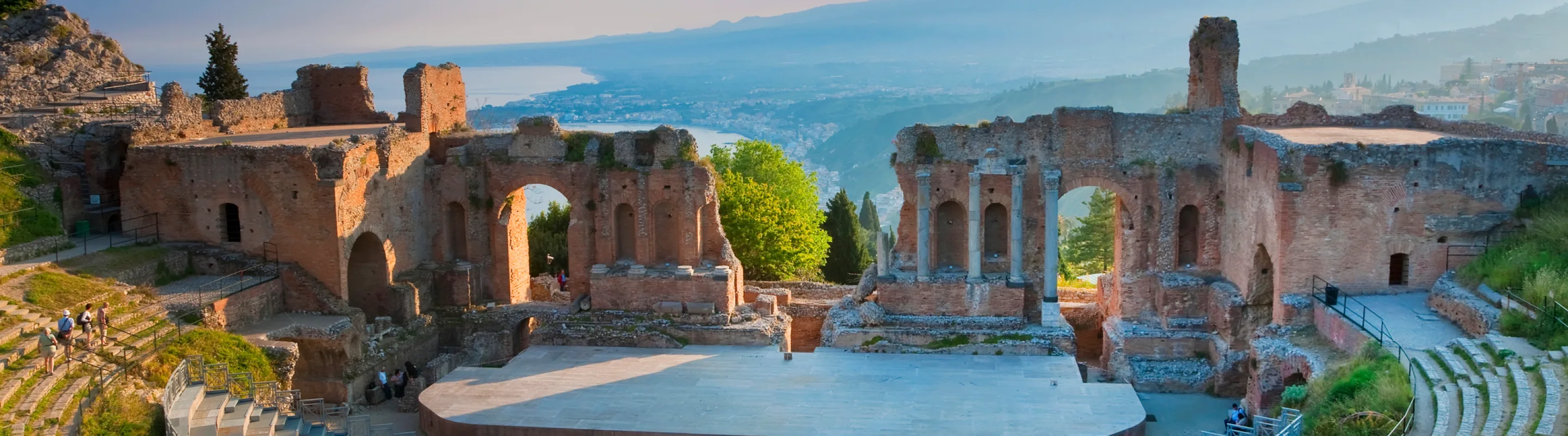 View of Greek theater at Taormina in Sicily with the ocean in the background, highlighting travel insurance for Italy