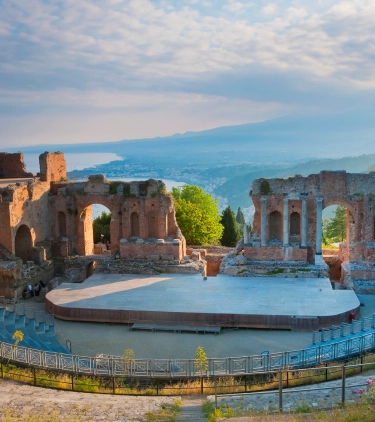 View of Greek theater at Taormina in Sicily with the ocean in the background, highlighting travel insurance for Italy