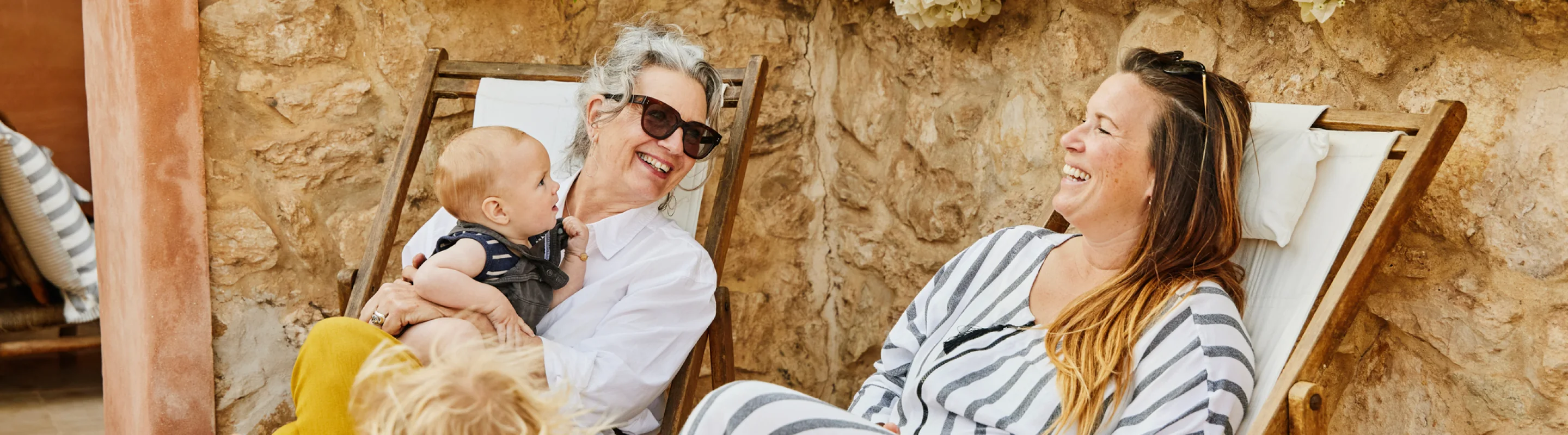 a multi-generational family with family travel insurance on vacation and lounging in chairs 