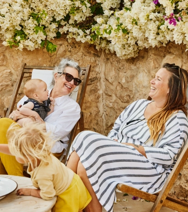 a multi-generational family with family travel insurance on vacation and lounging in chairs 
