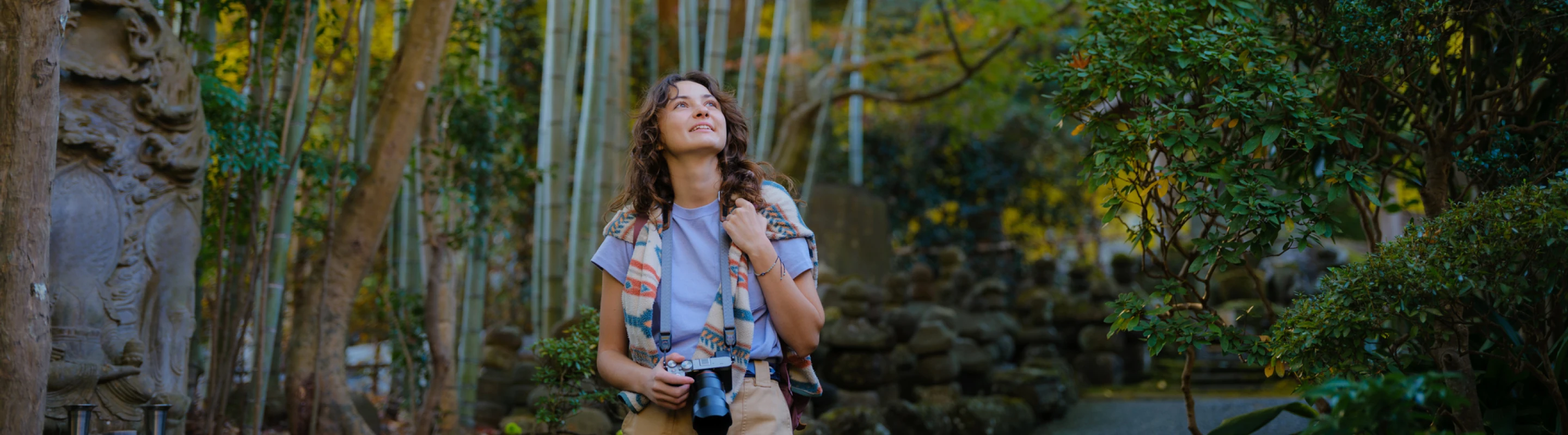 woman with travel insurance for Japan, walking through an oriental garden with bamboo