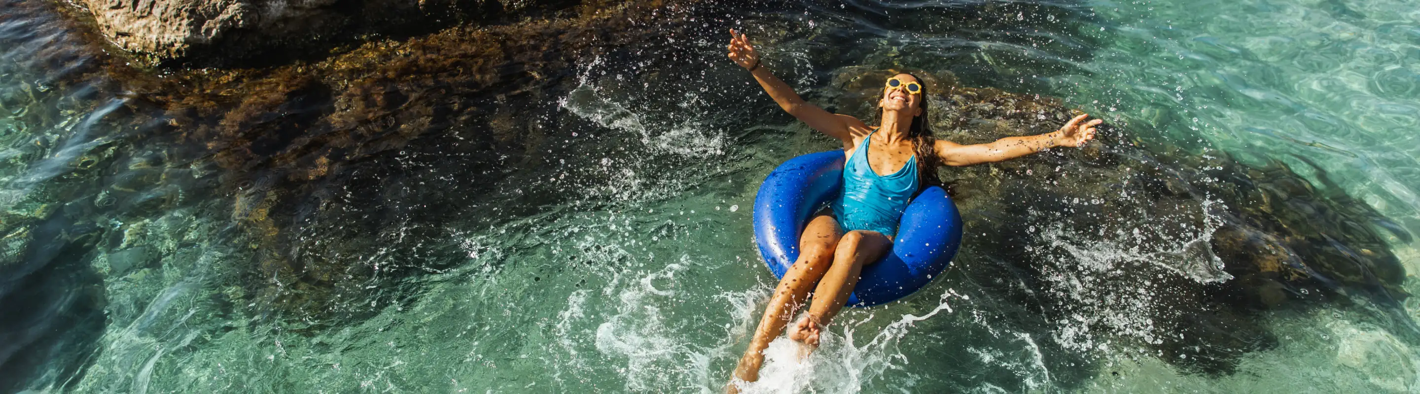 Woman with travel insurance for her all-inclusive vacation floating on an inner tube in the ocean