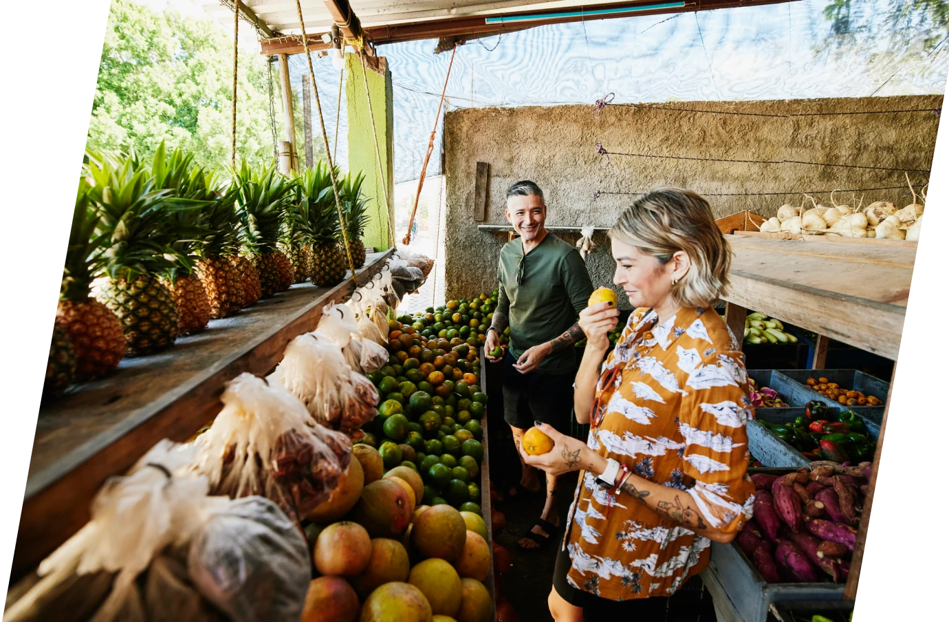 middle-aged couple with comprehensive travel insurance choosing fruit at a market in Mexico