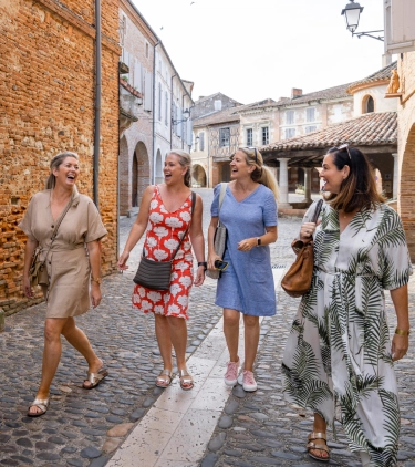women with travel insurance for France, laughing as they tour a local town in France