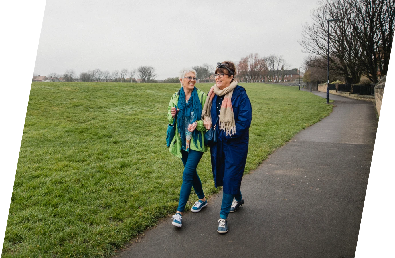 Two middle-aged women discussing Travelex support on a walk in the park