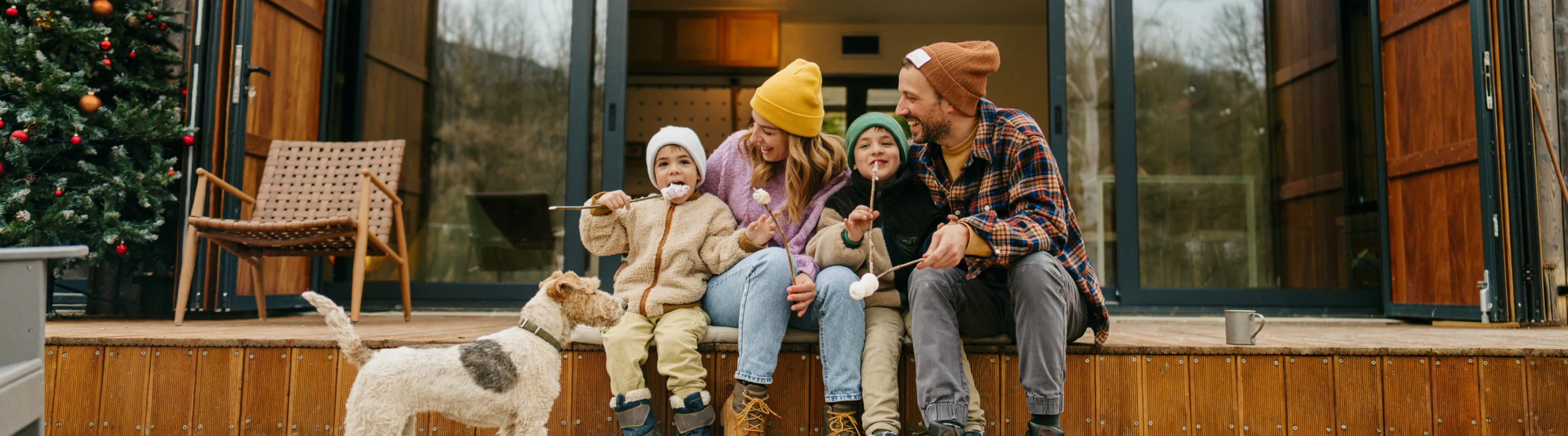 Parents with vacation rental travel insurance making smores at a cabin with their two young children