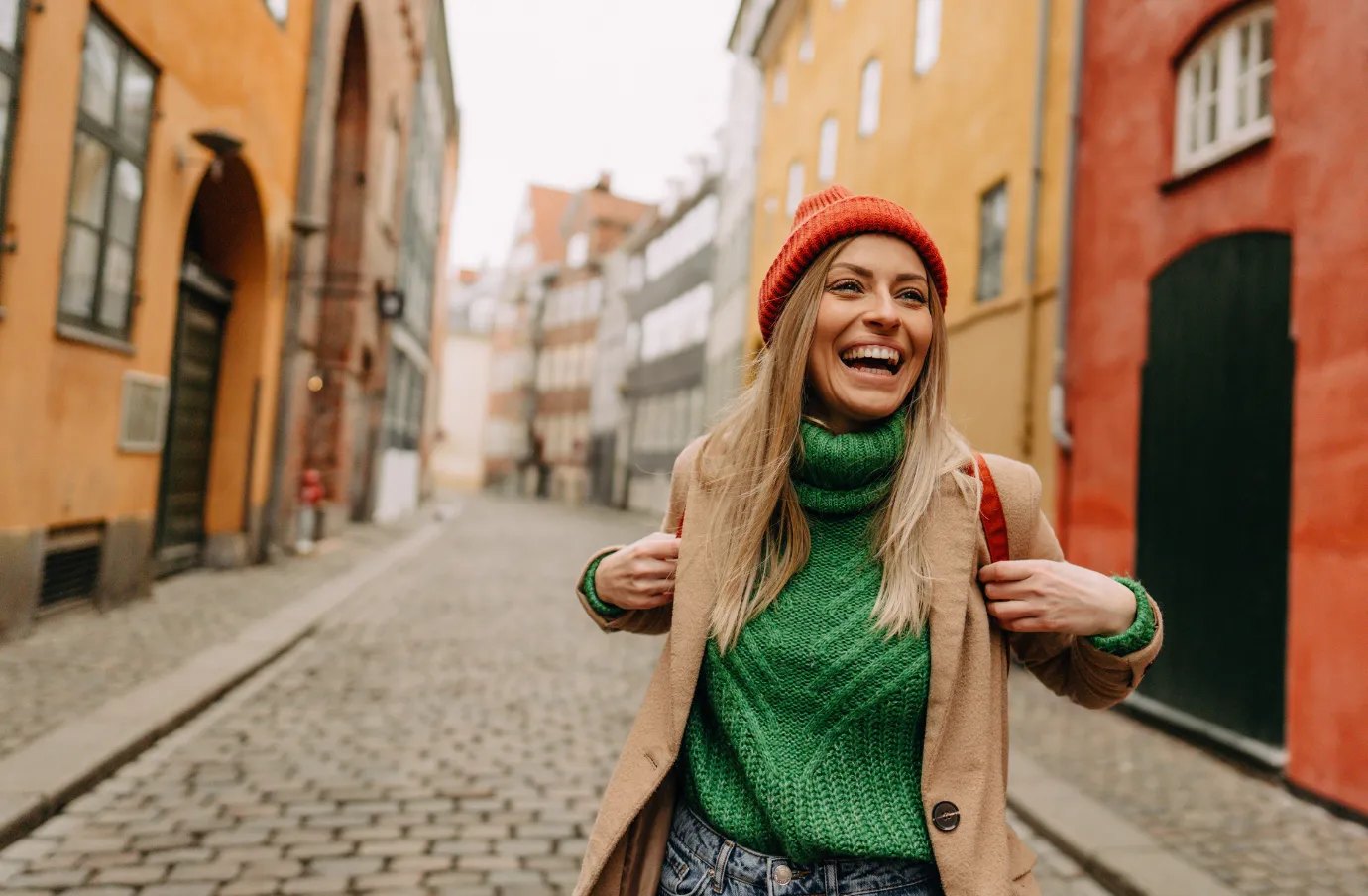 a female solo traveler walks down a historic street, insured with travel insurance for city trips 