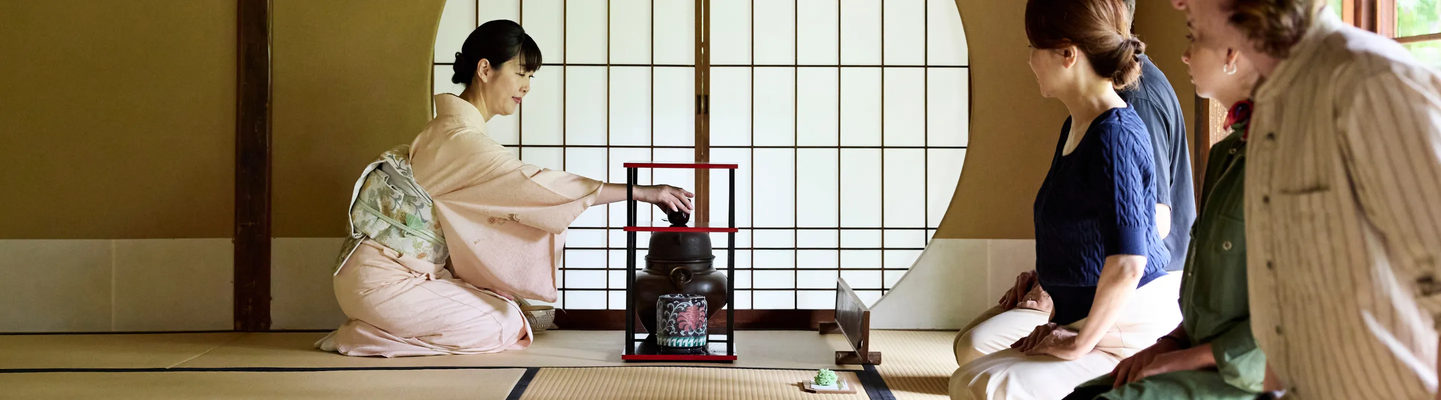 several travelers, with travel insurance for cultural trips, attend a traditional Japanese tea ceremony