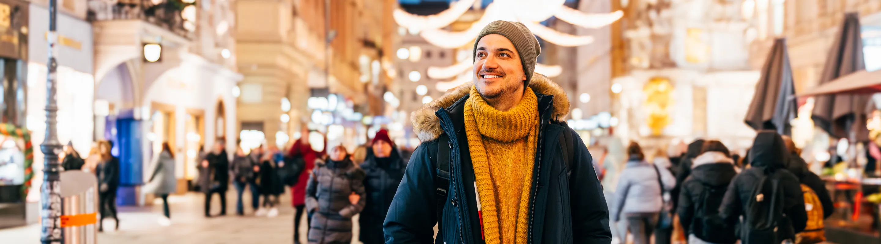 a man walking through Graben, Vienna, as night falls, insured with travel insurance for Austria 