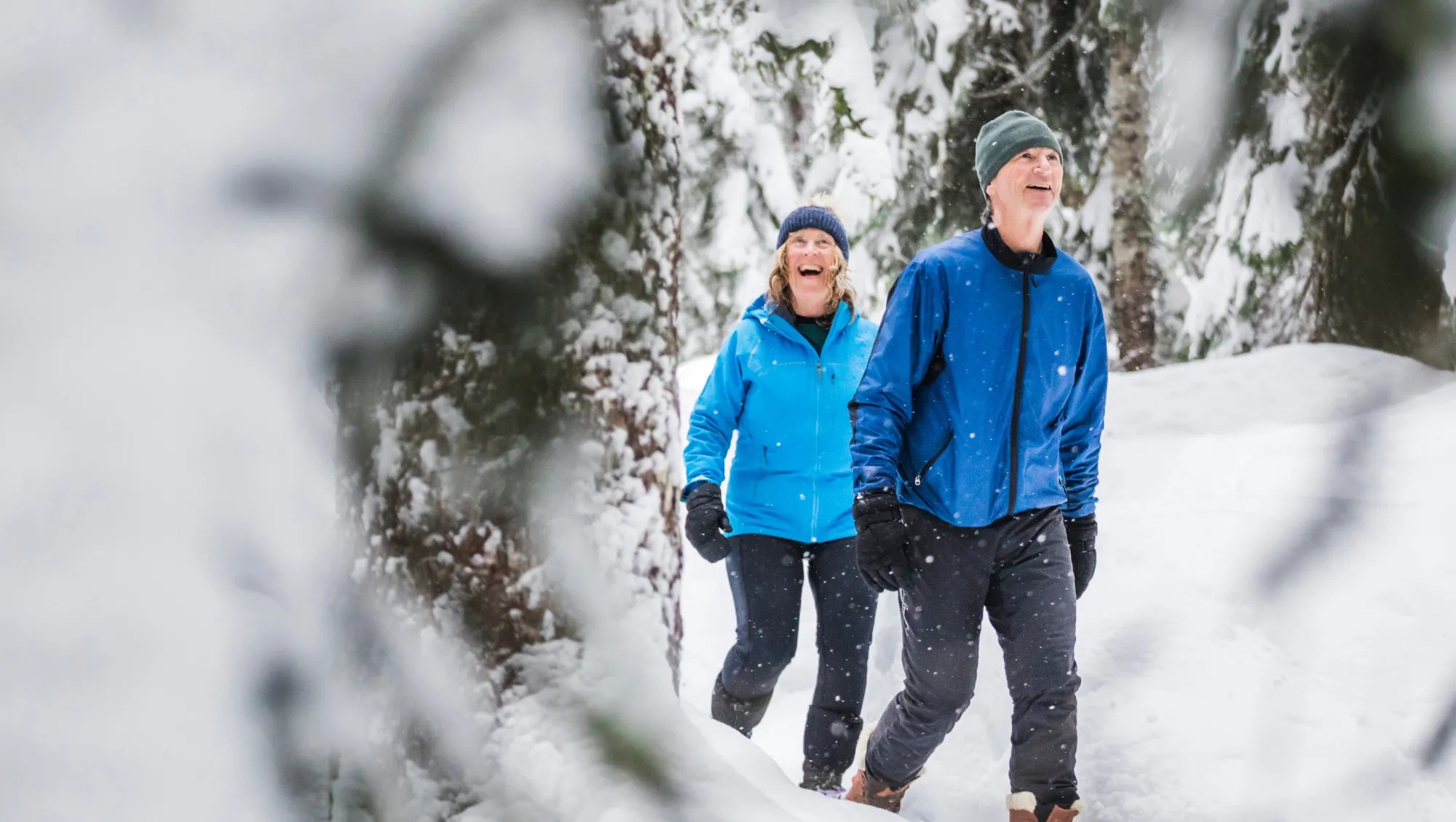 a mature couple snowshoes in Whistler, Canada, after researching "Does travel insurance cover snowstorms?"