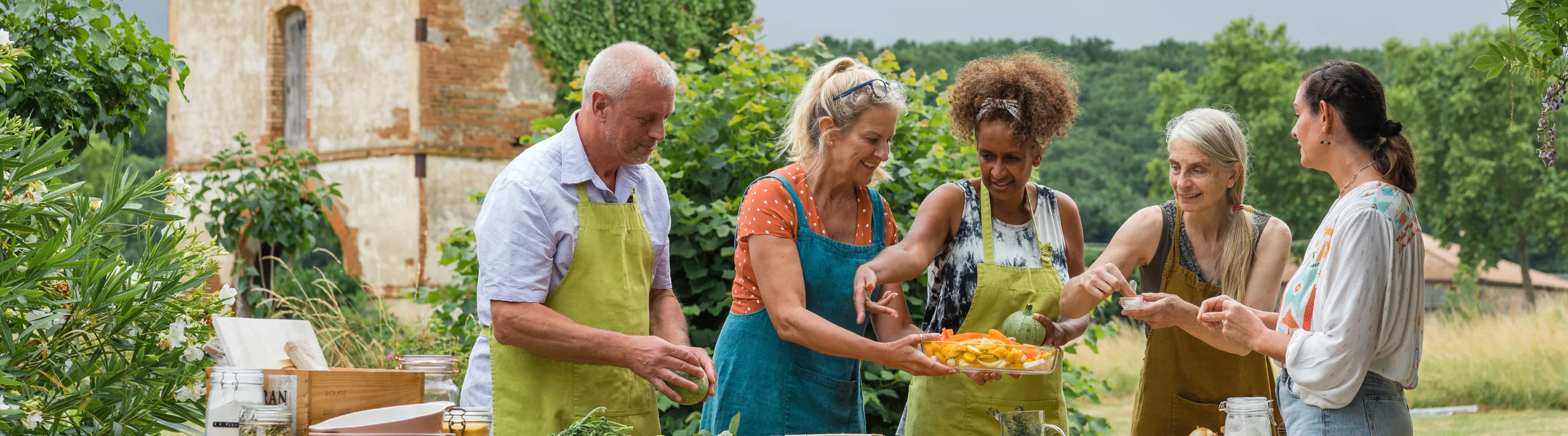 middle-aged travelers take a cooking class in the French countryside, insured with travel insurance for France 