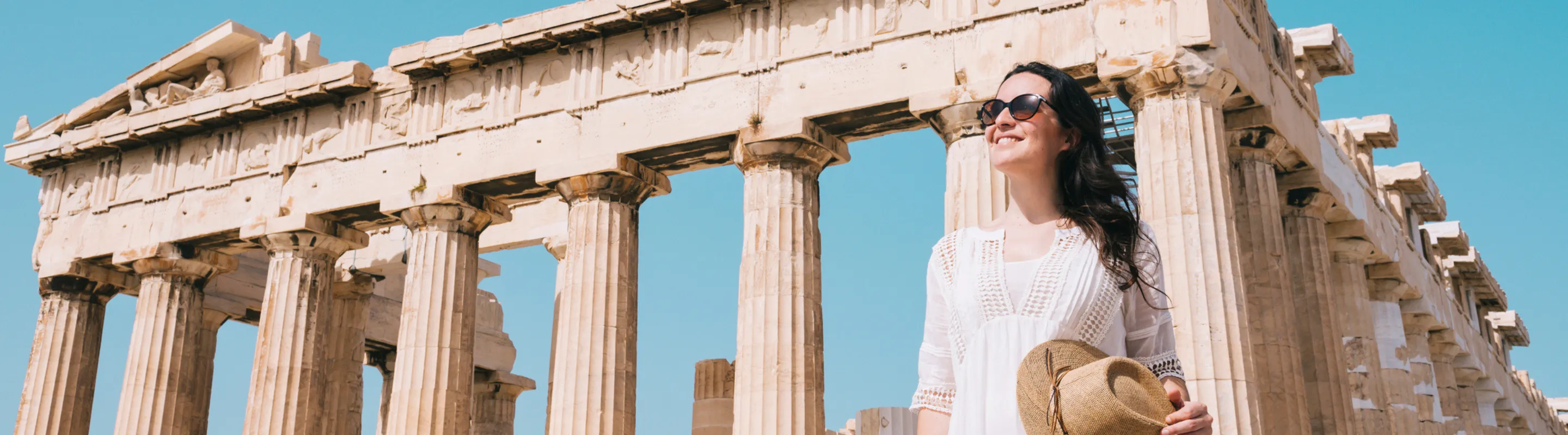 woman with travel insurance for Greece touring the Parthenon in Athens, Greece 