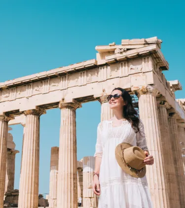 woman with travel insurance for Greece touring the Parthenon in Athens, Greece 