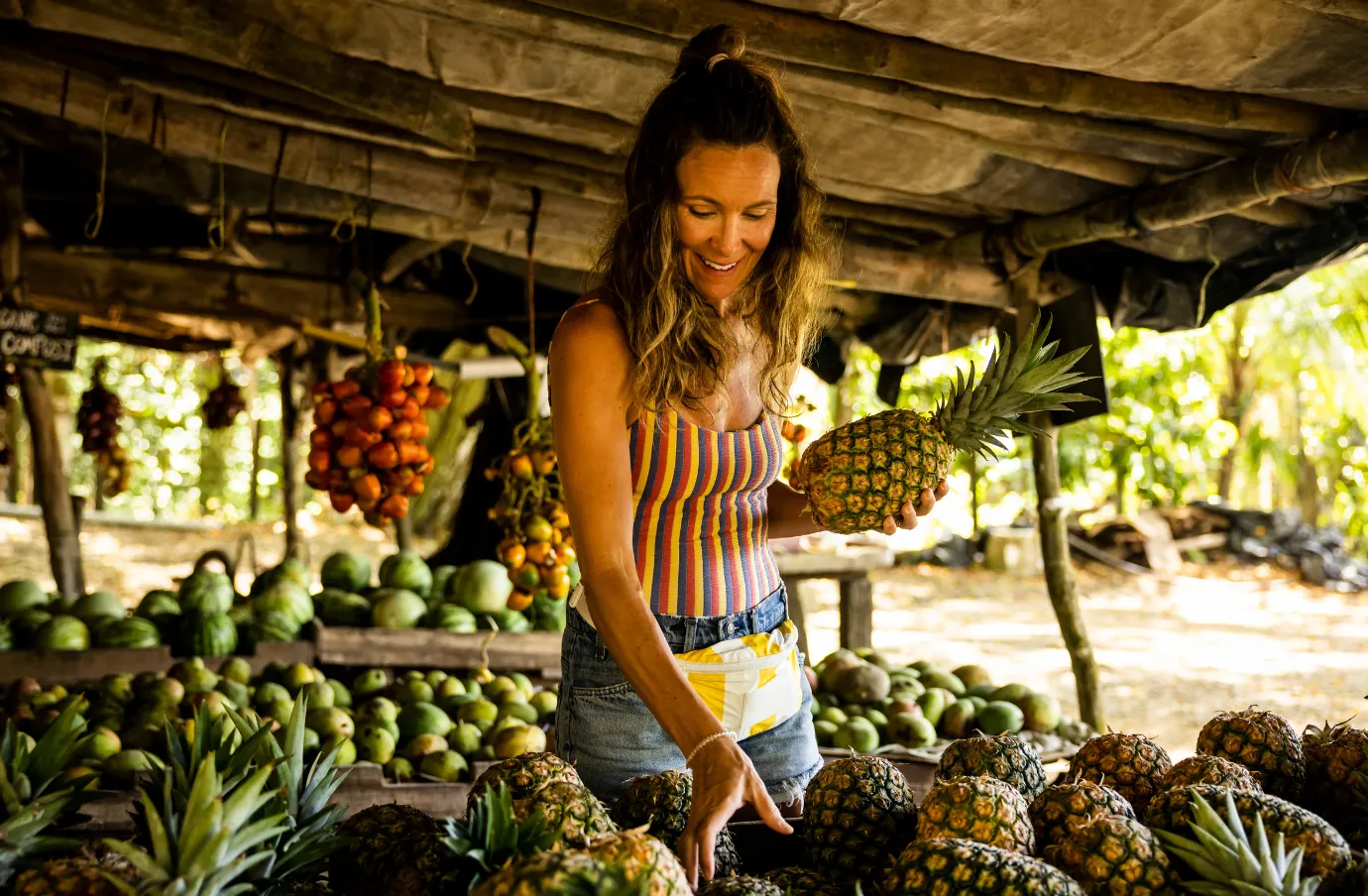 a young woman with travel insurance for Costa Rica buys fresh fruit at a fruit stand on vacation