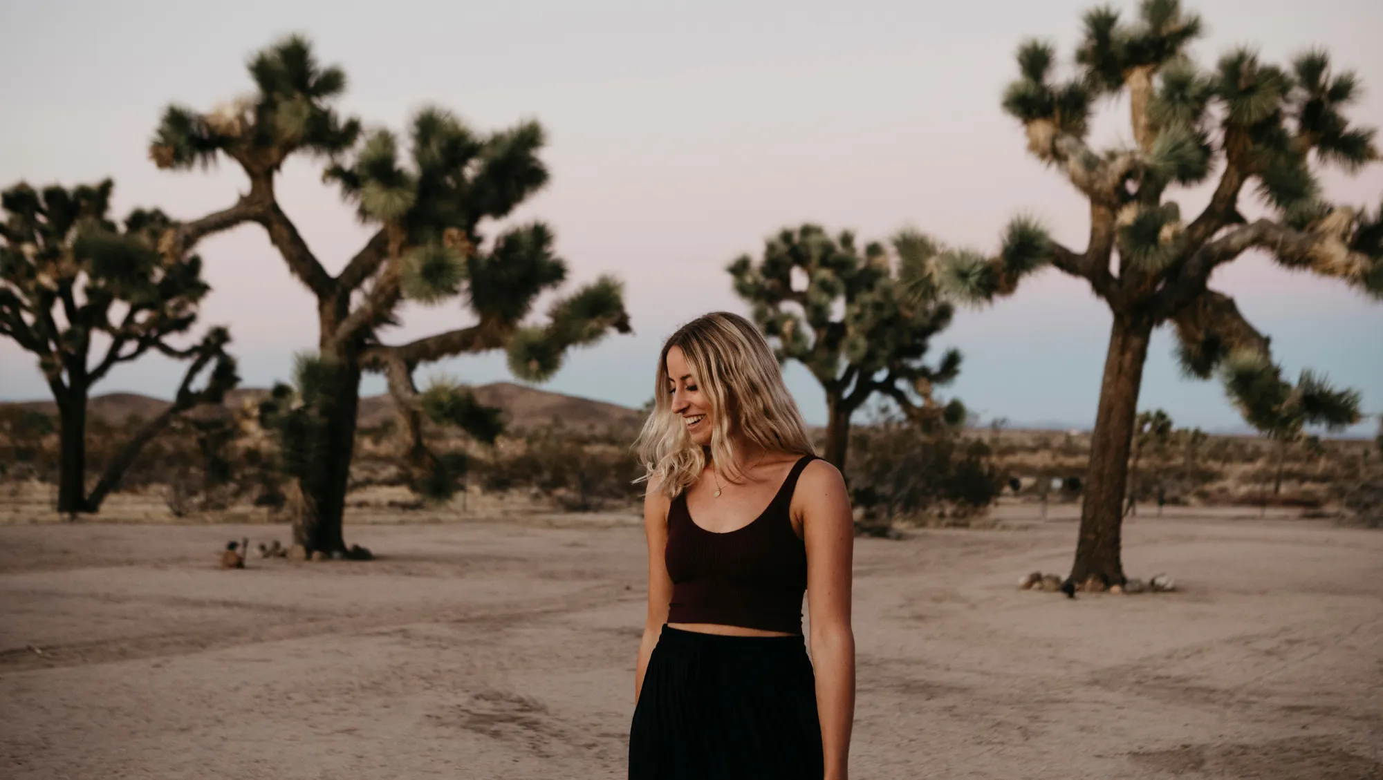 a woman explores Joshua Tree National Park on vacation after looking up "Is travel insurance worth it?"