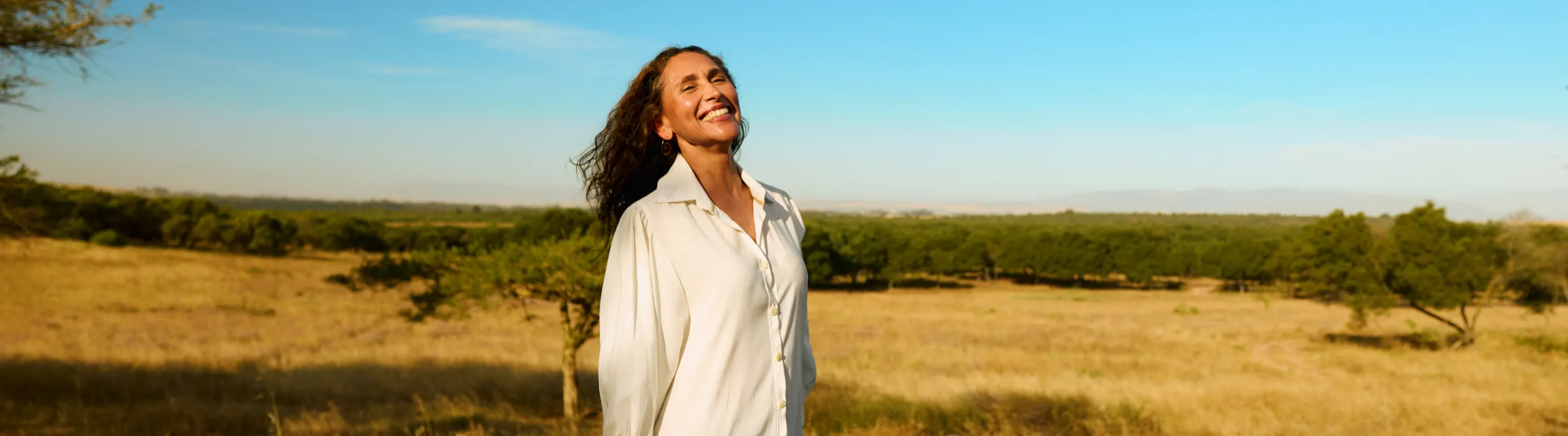 a woman stands in front of an infinity pool at a luxury safari lodge, insured with travel insurance for Africa 