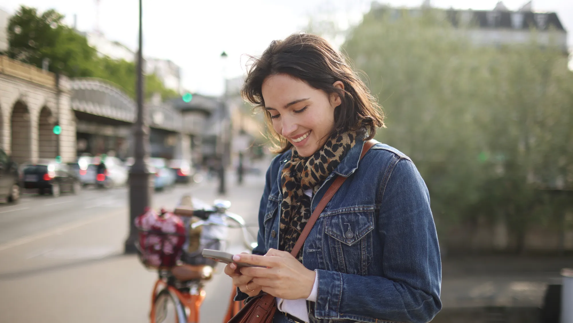 a woman uses the travel app on her phone during her vacation in Paris