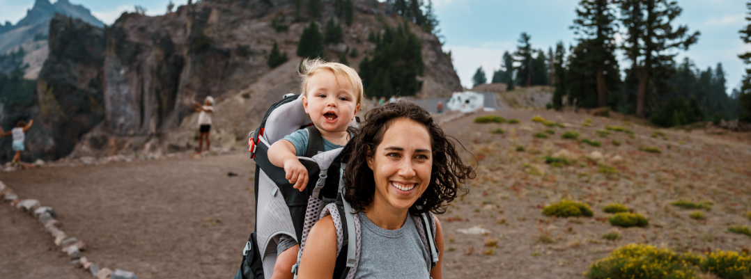 Happy baby hiking with his mom at a destination she discovered in a United States travel guide