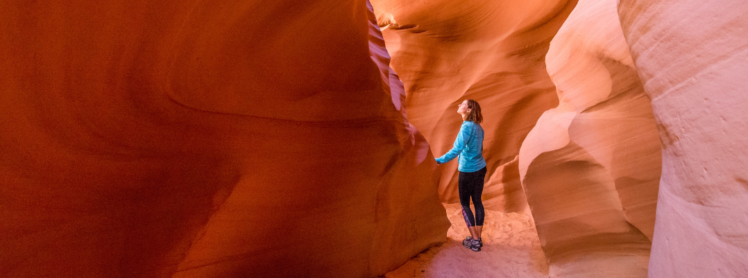 Woman looking at rock formations at Antelope Canyon in Arizona, one of the best places to travel as a solo female in the U.S.