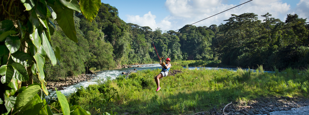 Woman smiling while zip-lining in Costa Rica, one of the best places to travel as a solo female in the U.S. and abroad