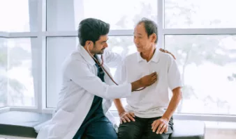 Doctor checking patient's heart at a travel health care appointment
