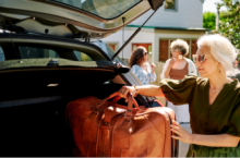 Elderly woman loading her baggage into a car trunk, which later becomes lost luggage